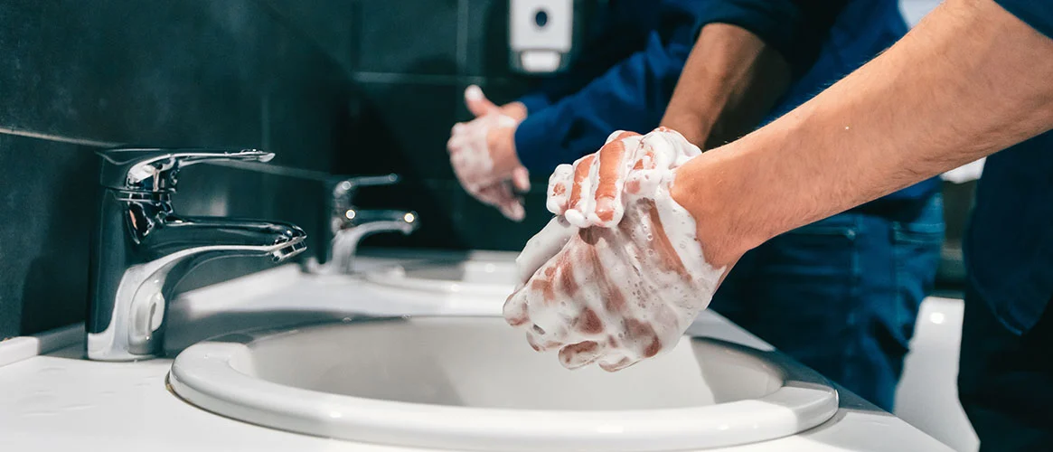 Person applying no rinse body wash to another’s back, demonstrating a quick and easy cleansing method for caregivers.